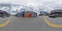 this is an 360 - view of graffiti on the street corner in front of two buildings