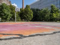 an empty parking lot in the city is cracked into two pieces and is completely painted to resemble a flower