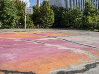 an empty parking lot in the city is cracked into two pieces and is completely painted to resemble a flower