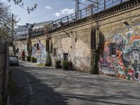 the graffiti is all over the building and walls on this side walk, with its colors