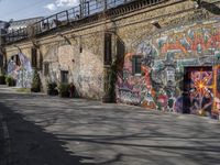 the graffiti is all over the building and walls on this side walk, with its colors