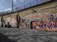 the graffiti is all over the building and walls on this side walk, with its colors