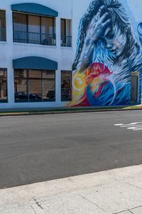 a mural on the side of a building has a horse in flames with a red fire hydrant by a fire hydrant