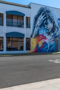 a mural on the side of a building has a horse in flames with a red fire hydrant by a fire hydrant