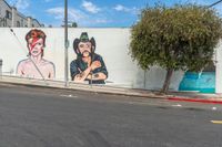 the mural on this wall is depicting mick and rod herring with music headphones and rock star hair