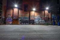 an empty parking lot has graffiti all over it in the dark night time, with the lights on