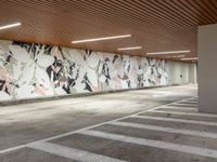 the empty empty parking lot is surrounded by modern decor murals and flooring tiles and concrete wall