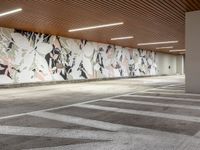 the empty empty parking lot is surrounded by modern decor murals and flooring tiles and concrete wall