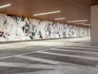 the empty empty parking lot is surrounded by modern decor murals and flooring tiles and concrete wall