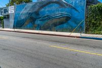 the mural on the side of a building has whales painted all over it to match the wall