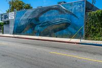 the mural on the side of a building has whales painted all over it to match the wall