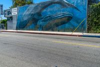 the mural on the side of a building has whales painted all over it to match the wall