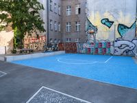 a basketball court with some graffiti painted on it in front of an apartment building in germany