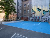 a basketball court with some graffiti painted on it in front of an apartment building in germany