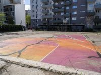 an empty parking lot painted with colorful paints on it and the grass in front is empty