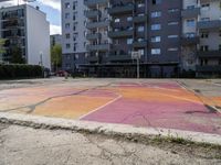 an empty parking lot painted with colorful paints on it and the grass in front is empty