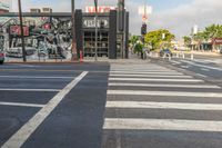 the cars are parked on the street and the white painted lines make a neat crosswalk