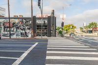 the cars are parked on the street and the white painted lines make a neat crosswalk