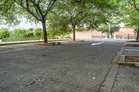 an empty parking lot and several trees in the background during the day with no one going down