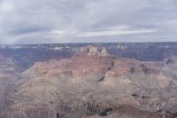 a man is riding on a horse at the grand canyon in arizona on a cloudy day