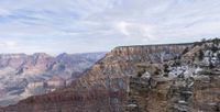 a view of the grand canyon from the top of the cliff, in the snow