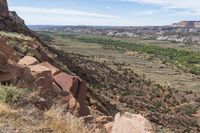 the scenic view of the grand canyon is framed by tall, thin boulders, rocks and brush