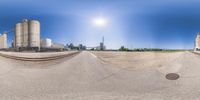 a fisheye view of cement silos with the sun in the background as if it were above the ramp