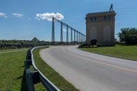 a bridge with two long towers in the distance is seen behind the road to the side