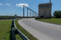 a bridge with two long towers in the distance is seen behind the road to the side