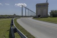 a bridge with two long towers in the distance is seen behind the road to the side