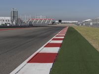 an empty track at a motorsports club with some red and white stripeing on it