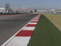 an empty track at a motorsports club with some red and white stripeing on it