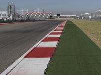 an empty track at a motorsports club with some red and white stripeing on it