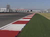 an empty track at a motorsports club with some red and white stripeing on it