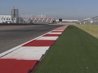 an empty track at a motorsports club with some red and white stripeing on it