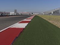 an empty track at a motorsports club with some red and white stripeing on it