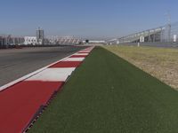 an empty track at a motorsports club with some red and white stripeing on it