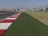 an empty track at a motorsports club with some red and white stripeing on it