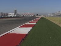 an empty track at a motorsports club with some red and white stripeing on it