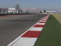 an empty track at a motorsports club with some red and white stripeing on it