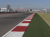 an empty track at a motorsports club with some red and white stripeing on it