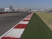 an empty track at a motorsports club with some red and white stripeing on it