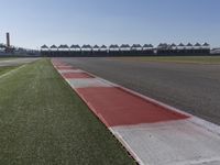 an empty track at a motorsports club with some red and white stripeing on it