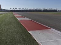 an empty track at a motorsports club with some red and white stripeing on it