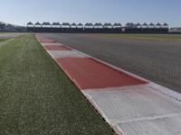 an empty track at a motorsports club with some red and white stripeing on it