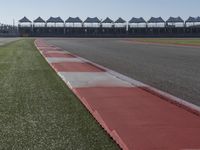 an empty track at a motorsports club with some red and white stripeing on it