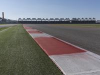 an empty track at a motorsports club with some red and white stripeing on it