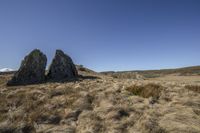 a field with rocks, grass and sky in the background to demonstrate something interesting is an area full of rocks