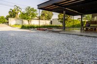 gravel area for driveways and parking in front of house with trees and walkways