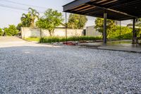 gravel area for driveways and parking in front of house with trees and walkways